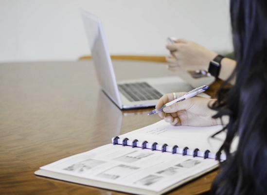 Vrouw schrijft in een schrift